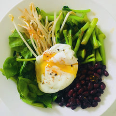 Green bowl with black beans and poached egg